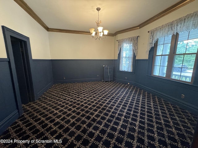 spare room with carpet flooring, a chandelier, and ornamental molding