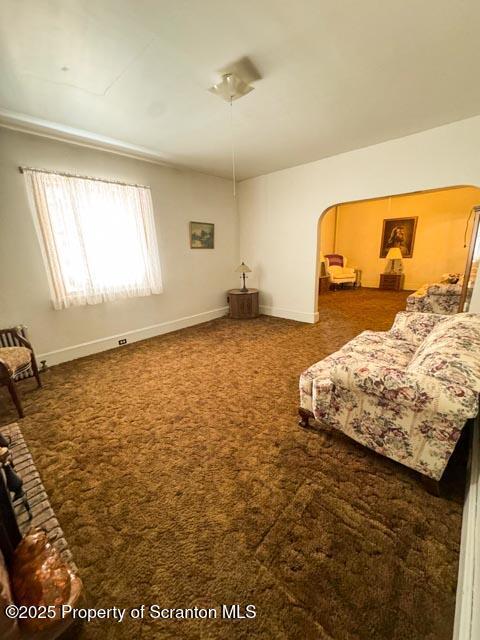 carpeted bedroom featuring baseboards and arched walkways