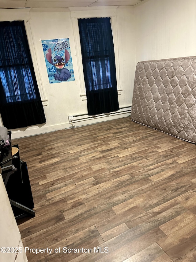 bedroom featuring hardwood / wood-style floors and a baseboard radiator