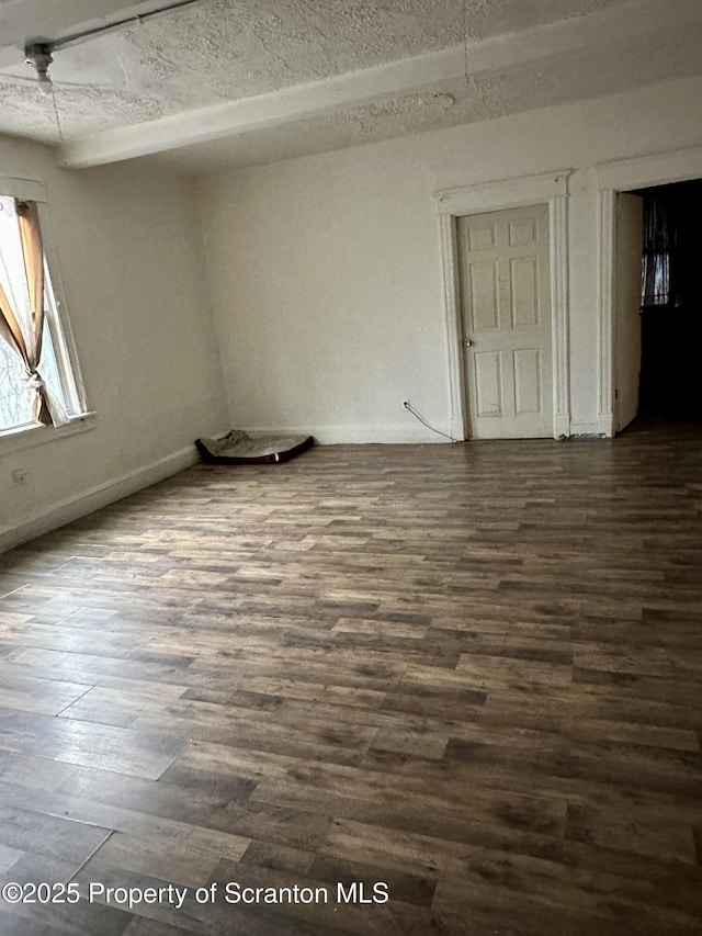 unfurnished room featuring ceiling fan, dark hardwood / wood-style floors, and a textured ceiling