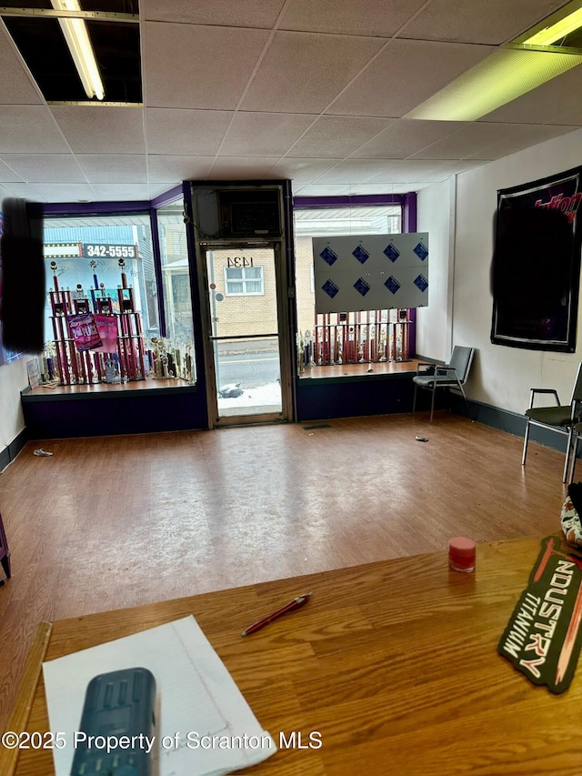 interior space featuring a paneled ceiling and wood-type flooring