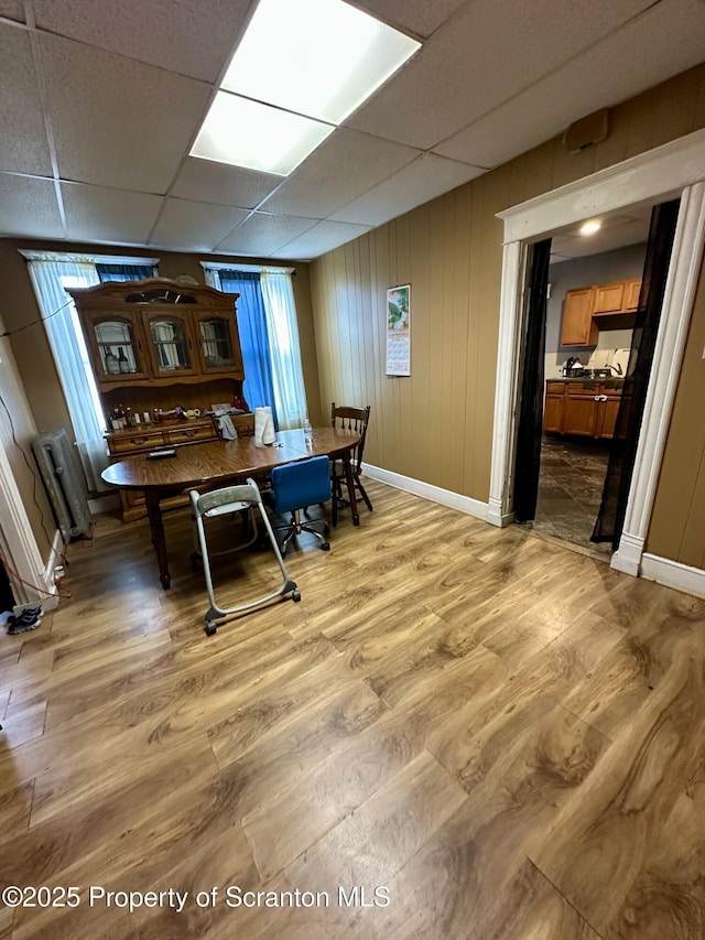 dining space with a paneled ceiling and wood-type flooring