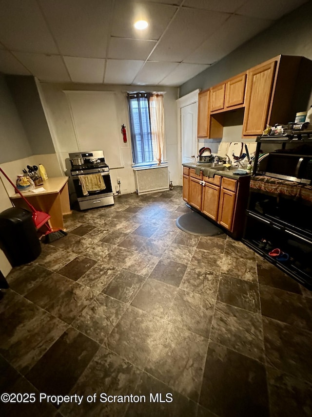 kitchen featuring appliances with stainless steel finishes, sink, and a drop ceiling