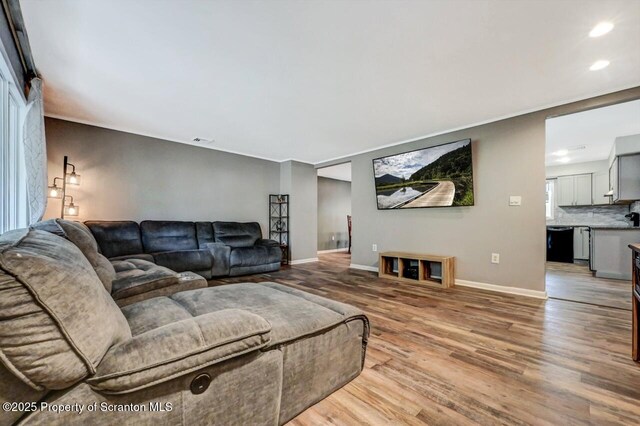 living area with light wood-style floors, recessed lighting, and baseboards