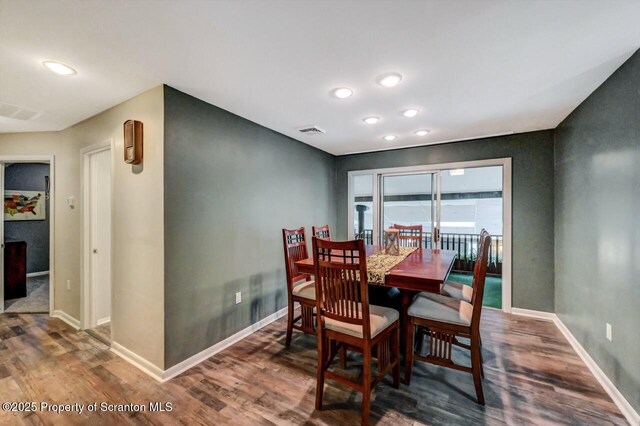 dining area with baseboards, wood finished floors, and recessed lighting