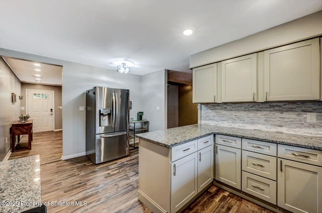 kitchen featuring black dishwasher, electric range oven, under cabinet range hood, wood finished floors, and tasteful backsplash