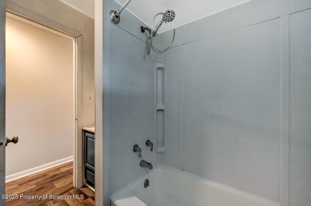 bathroom featuring wood finished floors, shower / bath combination, and vanity