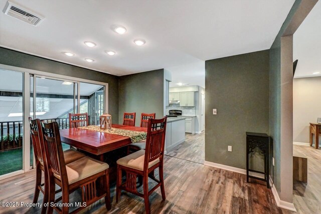 dining space featuring light wood-type flooring, baseboards, and recessed lighting