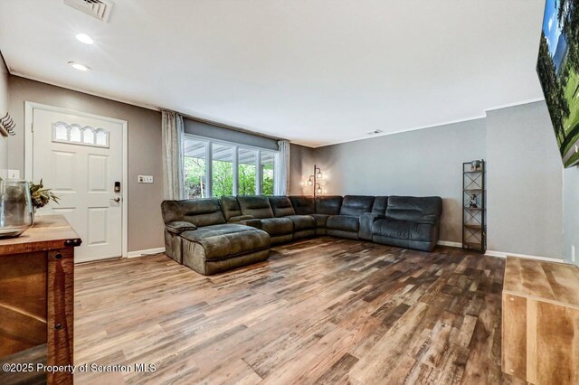 living room featuring wood finished floors, baseboards, and recessed lighting