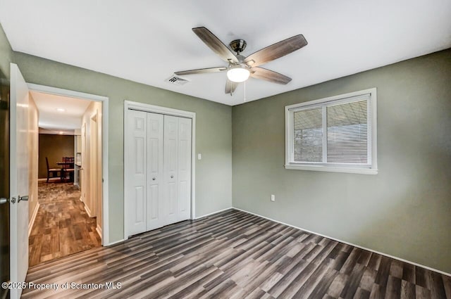 unfurnished bedroom with wood finished floors, a closet, and ceiling fan