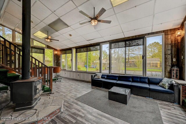 sunroom featuring a ceiling fan, an outdoor living space, and healthy amount of natural light