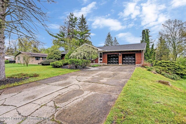view of front of house with brick siding, a garage, driveway, and a front yard