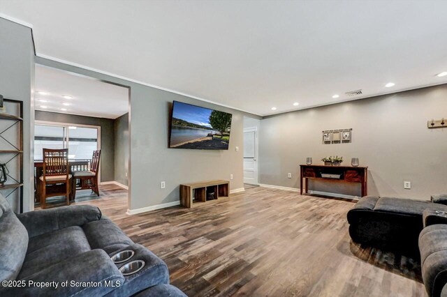 living area with wood finished floors, baseboards, and recessed lighting