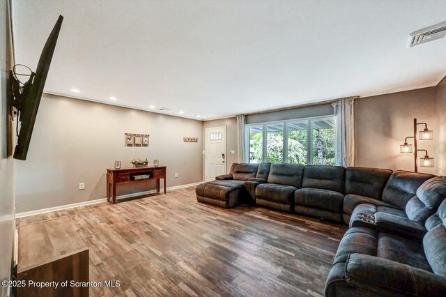 living room featuring wood finished floors, recessed lighting, and baseboards