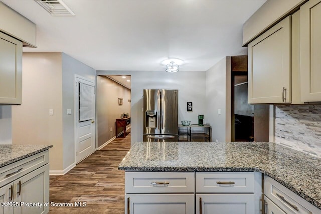 kitchen featuring stainless steel fridge with ice dispenser, black electric range oven, under cabinet range hood, light wood finished floors, and decorative backsplash