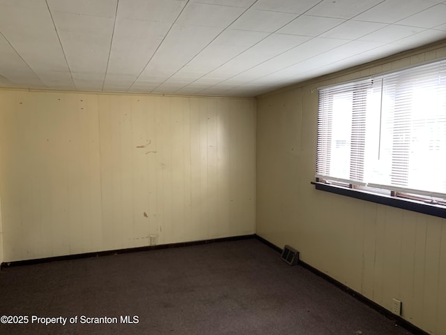 empty room featuring baseboards and carpet flooring