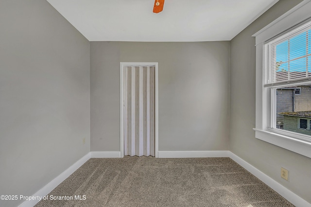 empty room featuring carpet flooring and baseboards