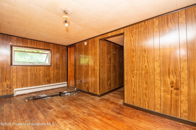 517 Emmett St, Scranton, PA 18505 - spare room featuring hardwood / wood-style floors, a baseboard heating unit, and wooden walls