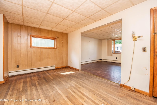 517 Emmett St, Scranton, PA 18505 - unfurnished room with a baseboard radiator, wood-type flooring, a drop ceiling, and wooden walls