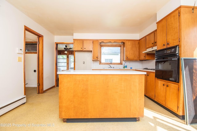 517 Emmett St, Scranton, PA 18505 - kitchen with oven, a baseboard heating unit, under cabinet range hood, a center island, and brown cabinets