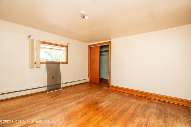 517 Emmett St, Scranton, PA 18505 - unfurnished bedroom with baseboard heating, light wood-type flooring, and a closet