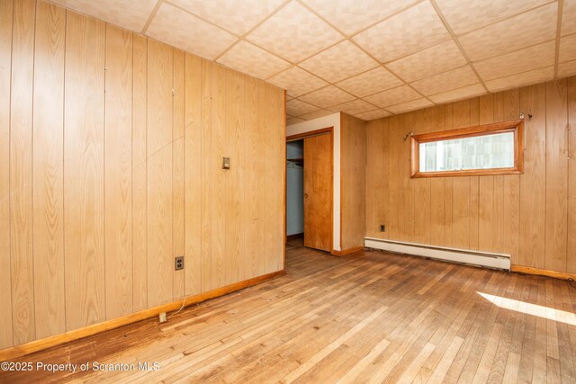 517 Emmett St, Scranton, PA 18505 - spare room with a baseboard radiator, hardwood / wood-style flooring, a drop ceiling, and wooden walls