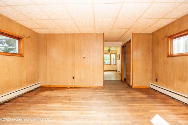 517 Emmett St, Scranton, PA 18505 - empty room with light wood-type flooring, baseboard heating, a baseboard heating unit, and wood walls