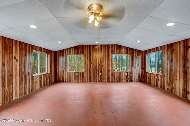 spare room with ceiling fan, a healthy amount of sunlight, a drop ceiling, and lofted ceiling