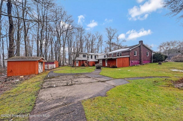 view of front of property featuring a shed and a front yard