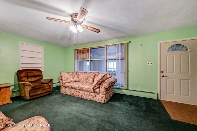 carpeted living room with ceiling fan and a baseboard heating unit