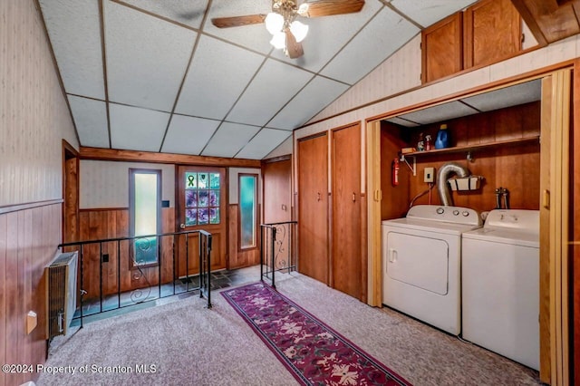 washroom featuring wood walls, radiator, ceiling fan, separate washer and dryer, and light colored carpet