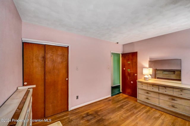 unfurnished bedroom featuring light wood-type flooring and a closet