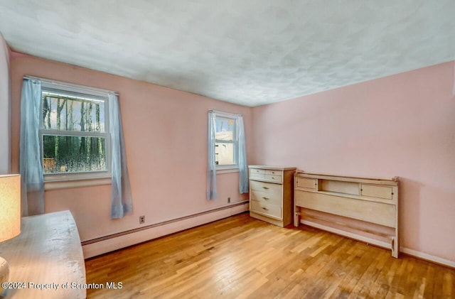 spare room featuring light hardwood / wood-style floors and a baseboard heating unit