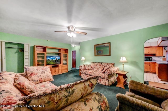 carpeted living room with ceiling fan