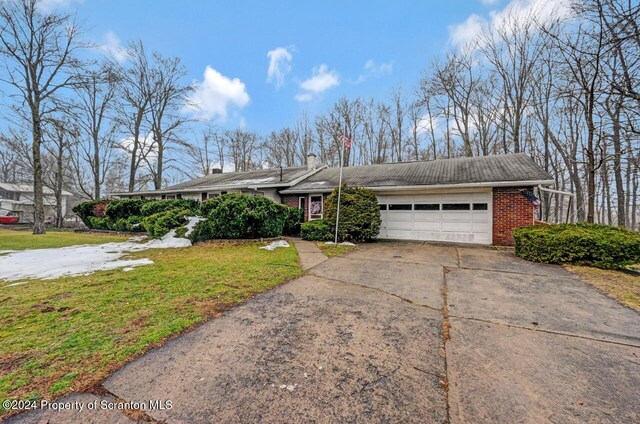 ranch-style home with a garage and a front lawn