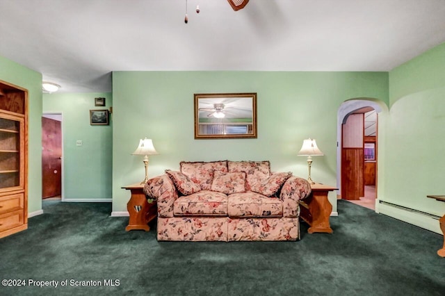 living room featuring dark colored carpet, ceiling fan, and a baseboard heating unit