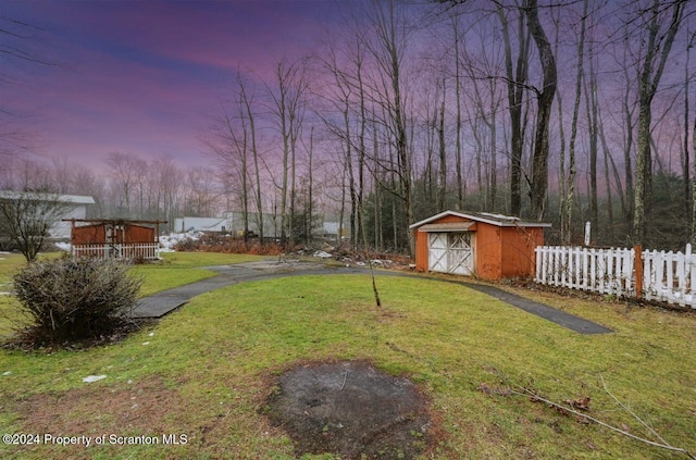 yard at dusk featuring a storage unit