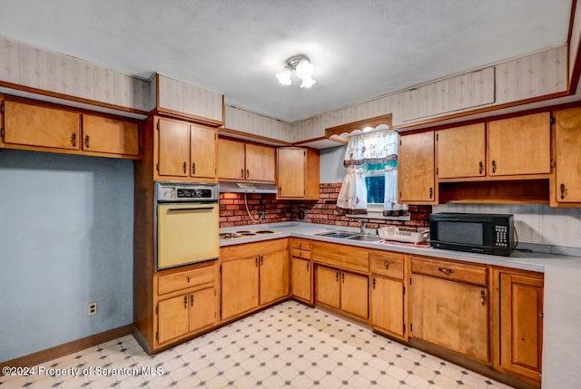 kitchen featuring white gas stovetop, sink, and oven