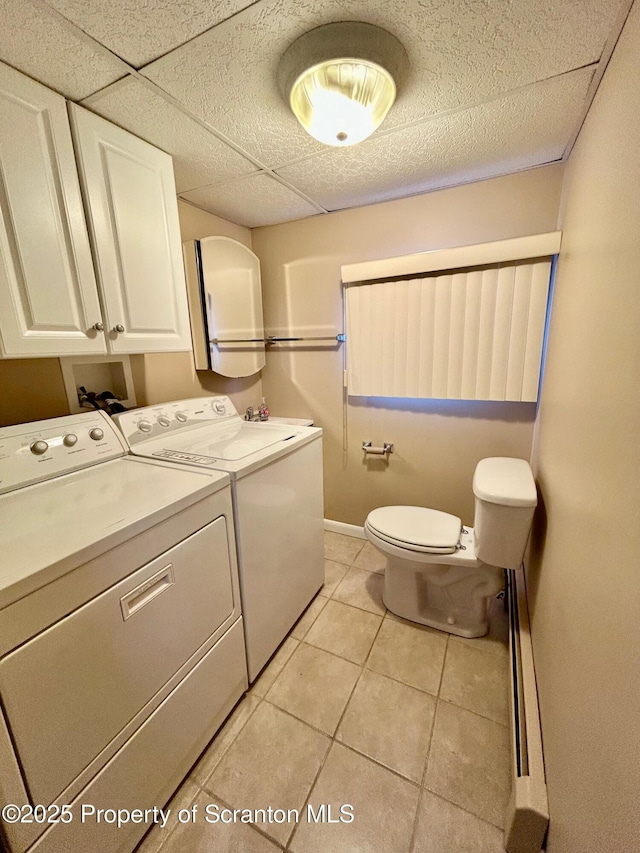 clothes washing area featuring light tile patterned floors and washer and dryer