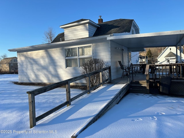 view of snow covered back of property