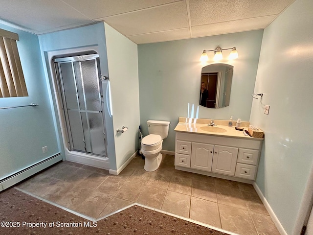 bathroom with tile patterned flooring, vanity, an enclosed shower, a drop ceiling, and toilet