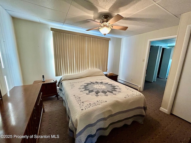 carpeted bedroom with ceiling fan and a baseboard heating unit