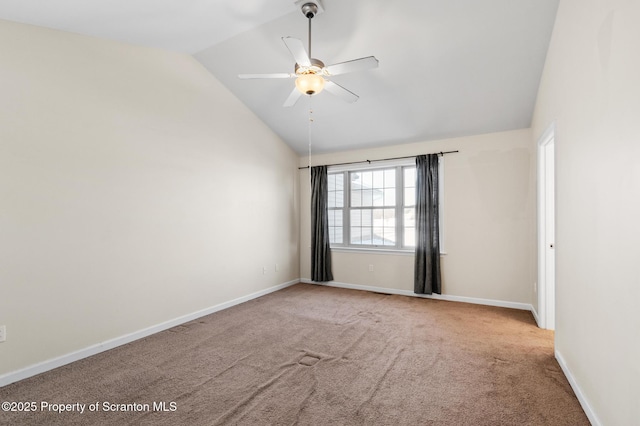 carpeted spare room featuring vaulted ceiling and ceiling fan