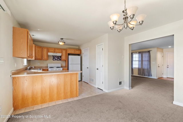 kitchen with range, decorative light fixtures, light carpet, kitchen peninsula, and white fridge