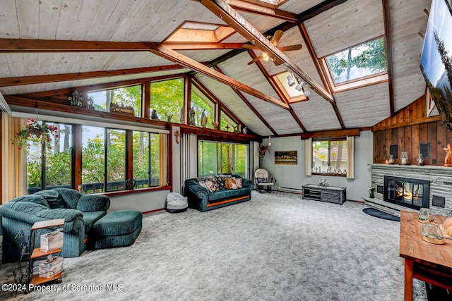 living room with carpet, a skylight, wood ceiling, wooden walls, and a stone fireplace