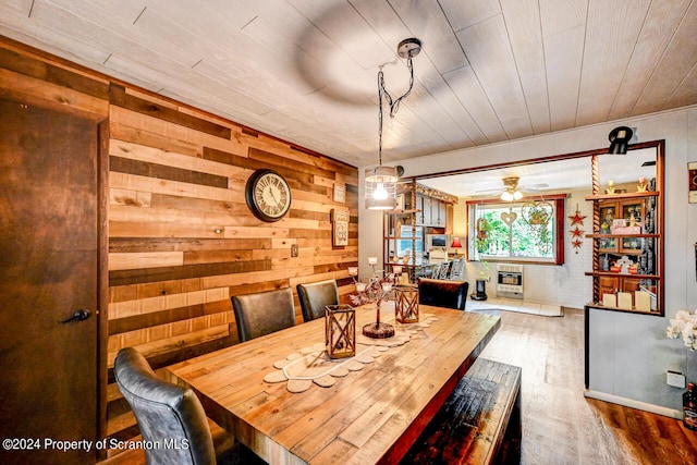 dining area featuring hardwood / wood-style floors, ceiling fan, wood walls, and wood ceiling