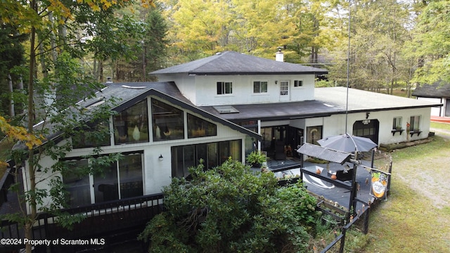 rear view of house featuring a yard and a sunroom