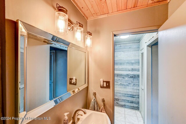 bathroom with wood ceiling, sink, and ornamental molding