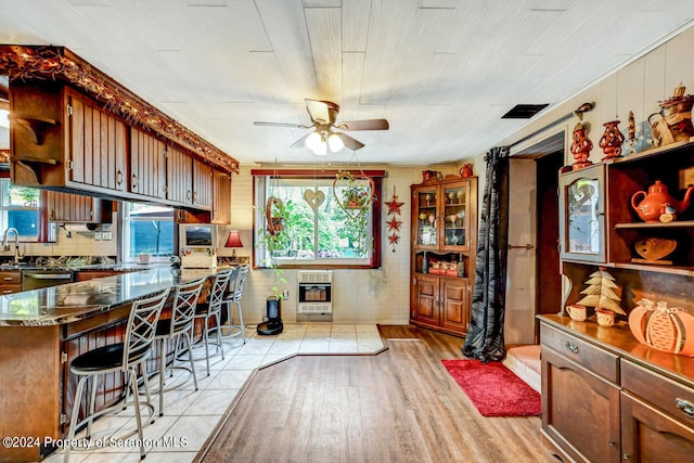 kitchen with a kitchen breakfast bar, light wood-type flooring, wood ceiling, heating unit, and ceiling fan