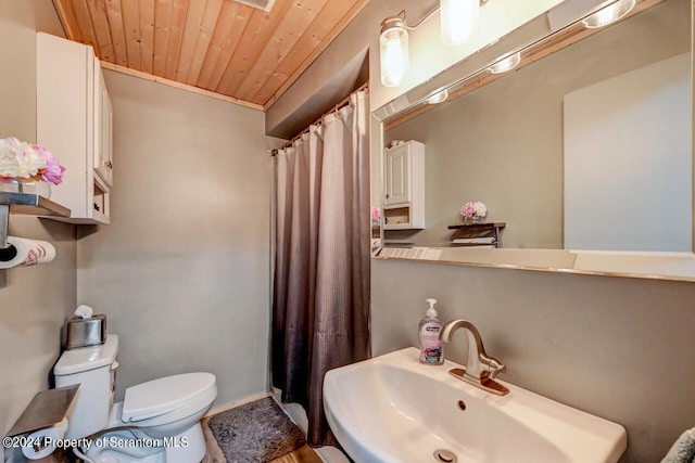 bathroom featuring toilet, wooden ceiling, and sink